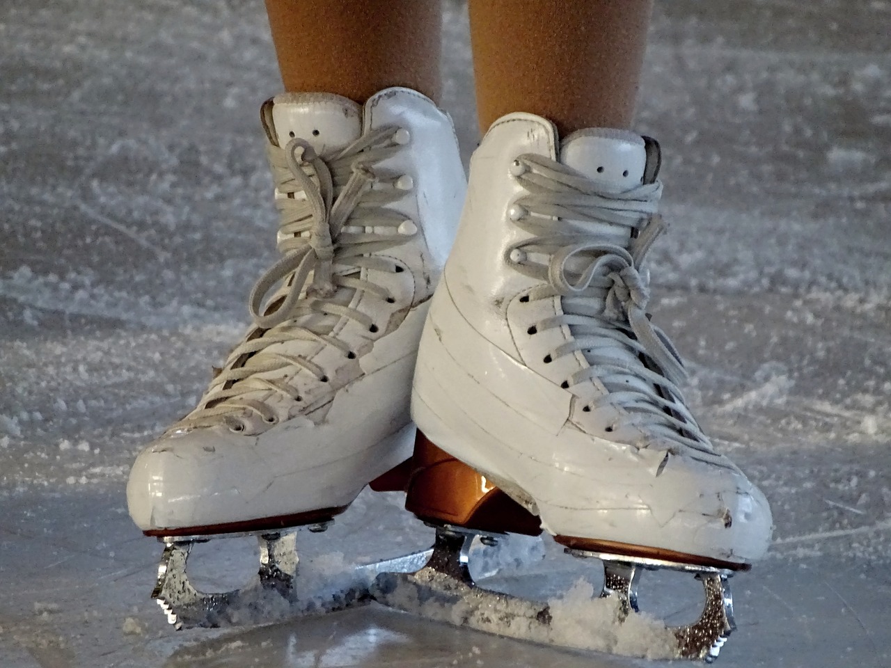 Białe łyżwy na stopach kobiety na tafli lodowiska w Wejherowie